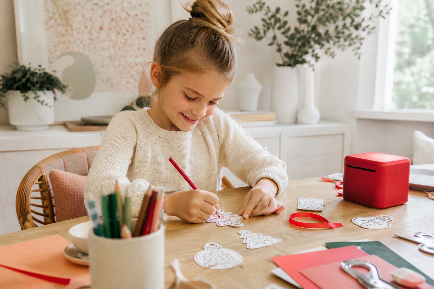 A child coloring handmade paper ornaments